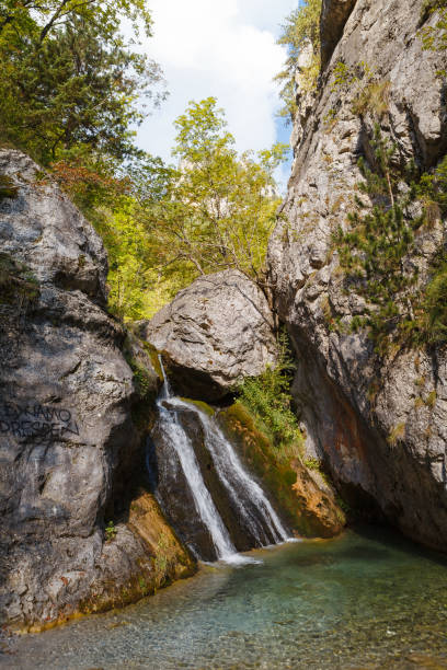 istock Enipeas waterfall with small lake surrounded by trees 1470001281