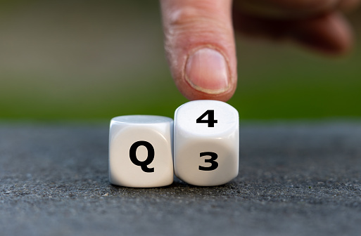 Symbol for the 4th Quarter of the year. Hand turns dice and changes the expression Q3 to Q4.