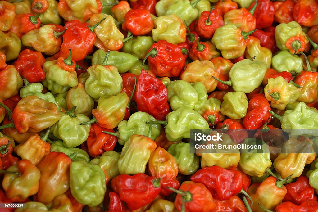 Red and Green Peppers on a pile Fresh and shiny red and green peppers piled up at a market. Bunch Stock Photo