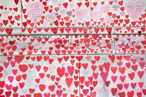 The National Covid Memorial Wall is in memory of the people who died due to Covid. Each of the hearts, with a hand written dedication inside, represents a person who is loved. The wall is run by bereaved volunteers and can be found opposite the Houses of Parliament in London, England. 18th August 2022.