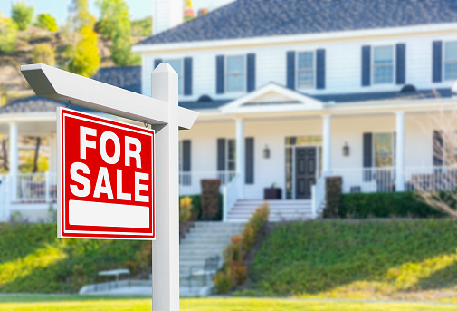 For Sale Real Estate Sign in Front of New House.