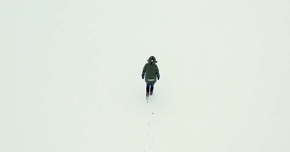 Aerial view of a woman walking on ice, on winter day
