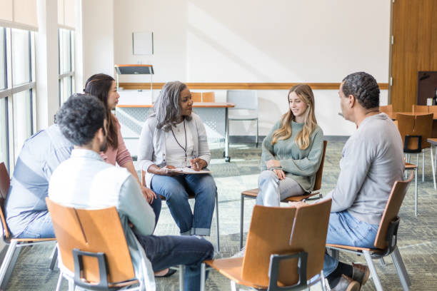 istock Multiracial, multigenerational support group listens to young woman 1470008235