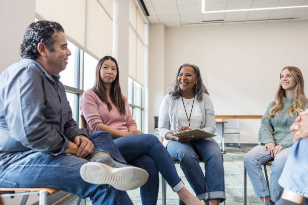 istock Members of support group smile with mature man 1470008237