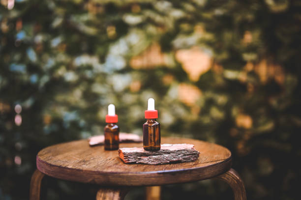 Dropper bottles of moisturizer on a wooden table with copy space. Amber-colored container with cosmetic product.