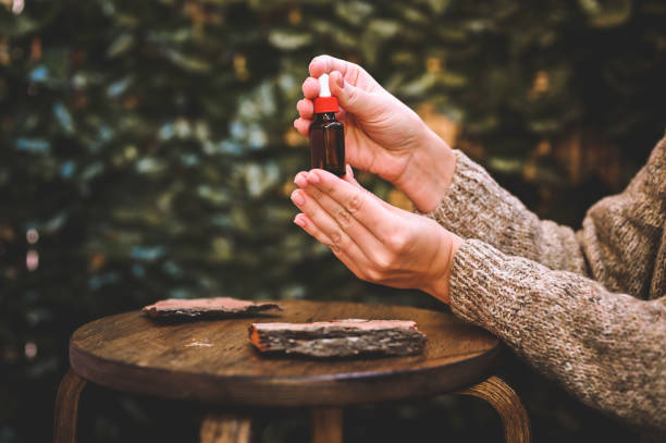 flacon en verre avec couvercle compte-gouttes dans les mains des femmes. - huiles essentielles photos et images de collection