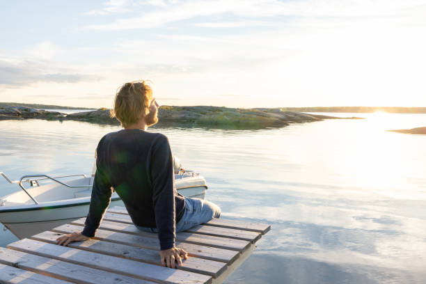 istock Man contemplates nature and reflection on the lake at sunset 1470010547