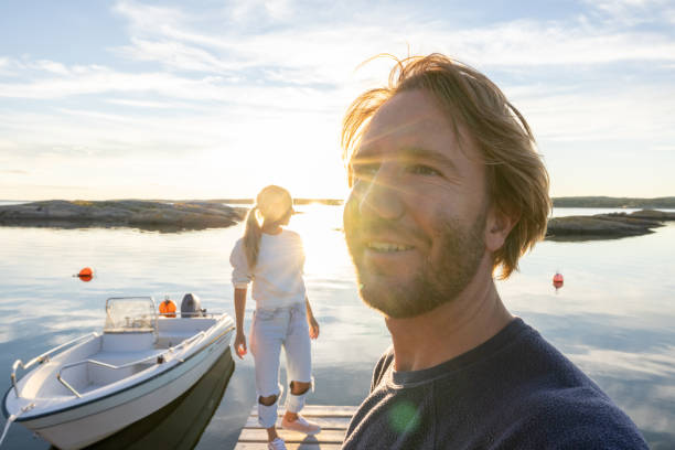 istock Couple relaxing on pier above lake at sunset 1470011400