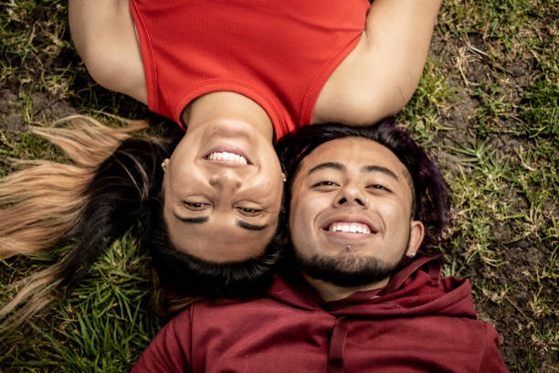 istock Young couple relaxing lying on grass outdoors 1470011775