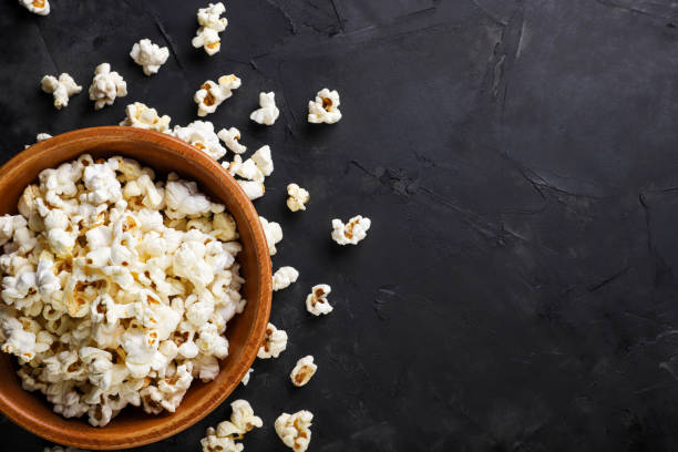 istock Popcorn in a wooden plate and scattered, space for text. Top view 1470011890