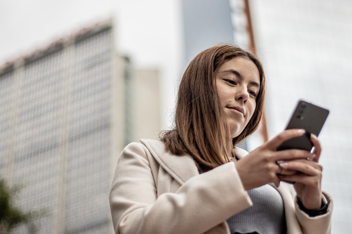 Young woman using mobile phone outdoors