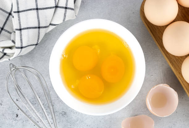 istock Raw eggs and whisk on a gray background, top view. Pie or cake recipe, breakfast concept, top view. 1470013557