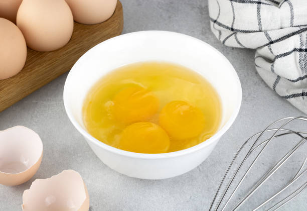 istock Raw eggs and whisk on a gray background. Pie or cake recipe. Breakfast concept. 1470013566