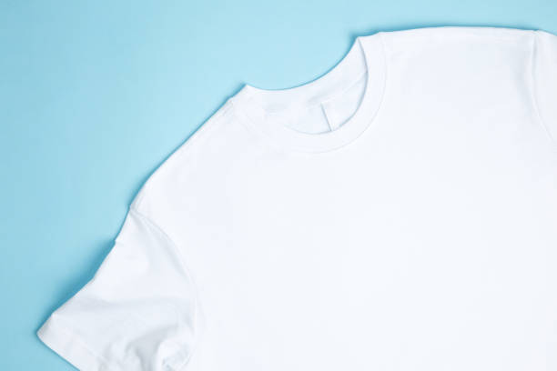 istock Basic folded white t-shirt blue background. Mock up for branding t-shirt. Copy space 1470014099