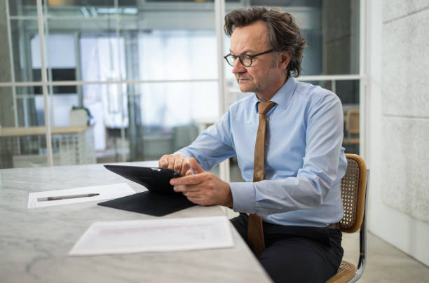 istock Businessman Talking On A Video Call Using Digital Tablet Computer In The Office 1470016006