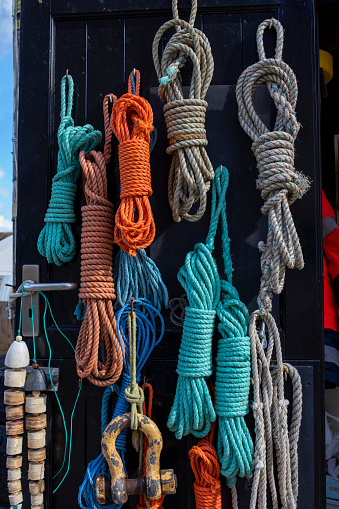 Different types of rope hanging on the back of a door in Mousehole, Cornwall.
