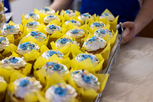 Close up shot of blue and yellow Ukraine themed cupcakes being sold for charity in Polperro, Cornwall.