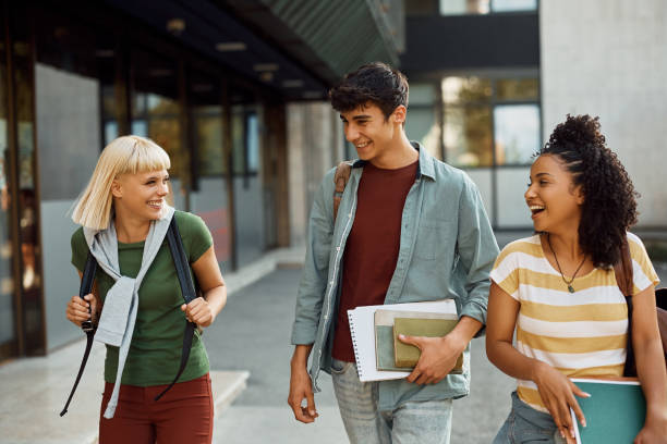 istock Group of happy college friends having fun while going on a lecture at campus. 1470018958