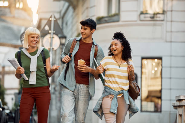 istock Young cheerful students talking while walking on the street. 1470019056