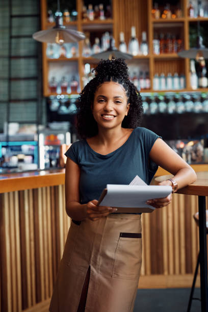istock Young happy black waitress working in a cafe and looking at camera. 1470019167