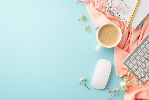 Business concept. Top view photo of keyboard computer mouse cup of fresh coffee notepad golden stationery gypsophila flowers and pink plaid on isolated pastel blue background with empty space