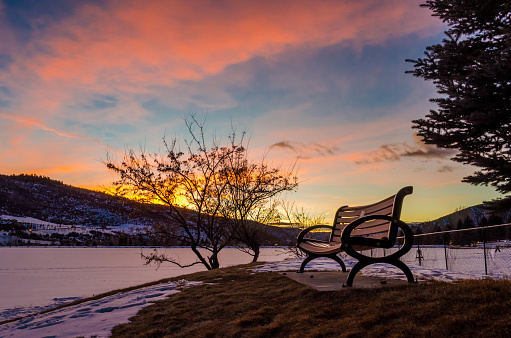 Bench by Nottingham Lake at sunset in Avon, Colorado in the winter.