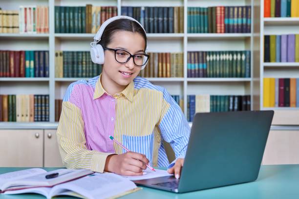 istock Teenage girl student studying in library, using laptop 1470021846