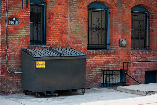 dumpster in an alley Clean front surface of a dumpster behind an apartment building. no parking sign photos stock pictures, royalty-free photos & images