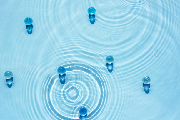 istock Water blue background with ripples and circles texture and transparent granules 1470023868