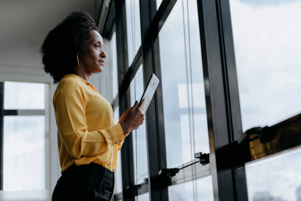 istock A businesswoman holding digital tablet looking at window view 1470025387
