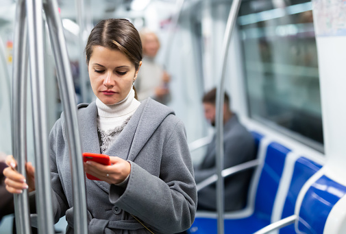 Woman with smartphone in subway car