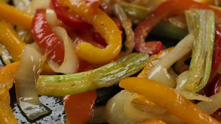 Super close-up of the colorful peppers and celery and onion stir-frying on pan