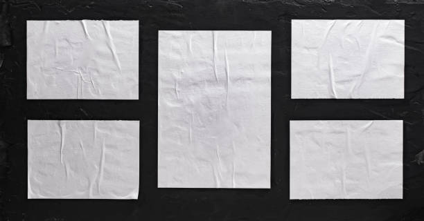 istock Five sheets of white paper pasted on a black wall. Layout for design. 1470028074