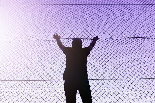 istock man climbing the metal fence 1470030533