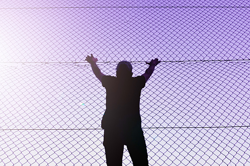 man climbing the metal fence