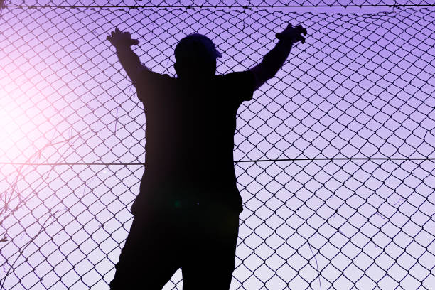 istock man climbing the metal fence 1470030543