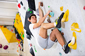 Man training at bouldering gym without special climbing equipment