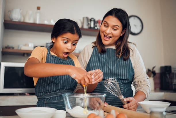 istock Family, cooking breakfast and child learning in kitchen for chef training, development support and food teamwork in home. Mother, girl and baking for love, quality time or bonding to prepare recipe 1470031017