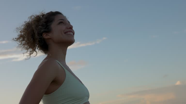 Beautiful young woman feeling free and happy at the beach looking away smiling