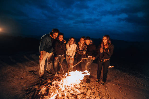 Happy group of friends in a circle around a bonfire