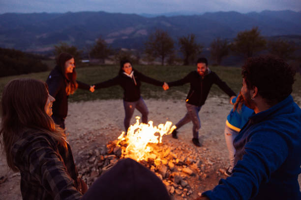istock Happy group of friends in a circle around a bonfire 1470032843