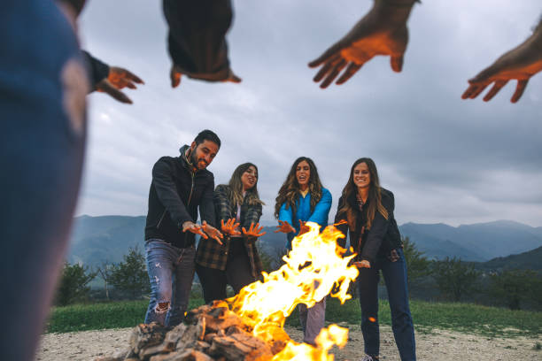 istock Happy group of friends in a circle around a bonfire 1470032895