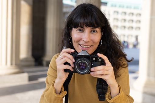 Young woman traveler  taking a photo with a camera - stock photo
