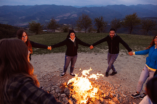 Friends celebrating and having fun around a bonfire.