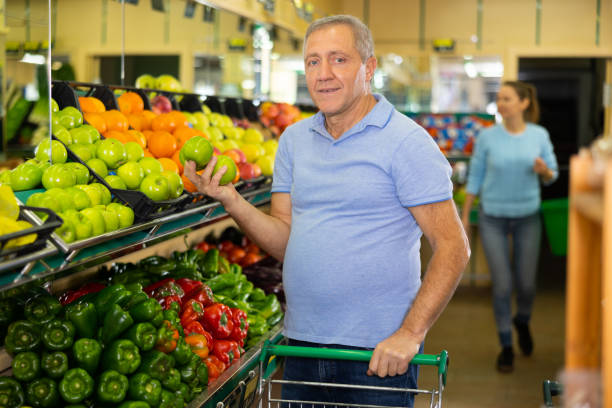 man buys apples in  supermarket