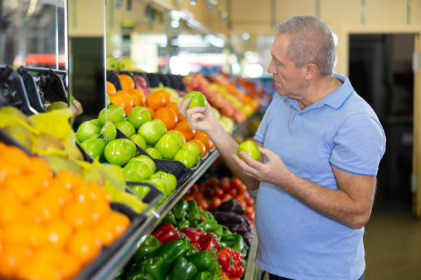 istock Elderly man purchaser buying fresh apples in grocery store 1470034024