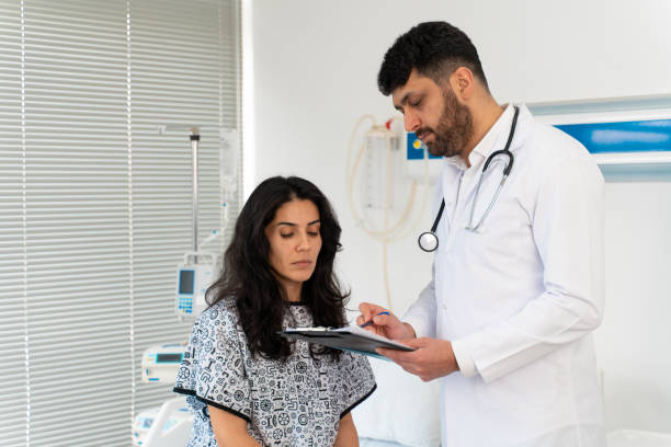 istock Female patient sitting on examination table in doctor's office 1470034027