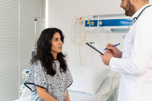 istock Female patient sitting on examination table in doctor's office 1470034160