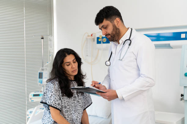 istock Female patient sitting on examination table in doctor's office 1470034279