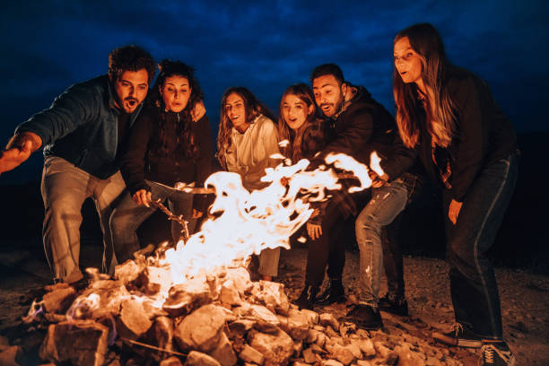 istock Happy group of friends in a circle around a bonfire 1470034334